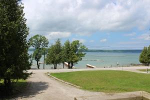 a path leading to a beach with trees and water at Bayshore Cottages in Wiarton
