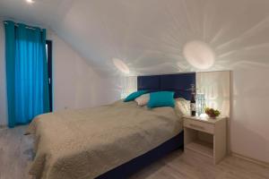 オストロボにあるApartamenty Żagielのベッドルーム1室(青いヘッドボード付きのベッド1台付)