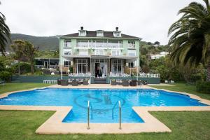 ein großes Haus mit Pool davor in der Unterkunft Hotel Isla Seca in Zapallar