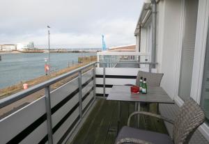 ヘルゴラントにあるAppartements am Binnenhafenの水辺の景色を望むバルコニー(テーブル、椅子付)