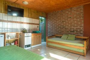 cocina con cama y pared de ladrillo en Cabañas Piedra Blanca, en El Quisco
