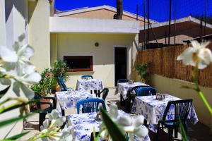 a group of tables with blue chairs and flowers at Guest House Li Minnanni in Olbia