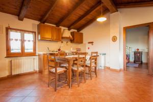 a kitchen with a wooden table and some chairs at Il Gelso 'd la Costa in Lesegno