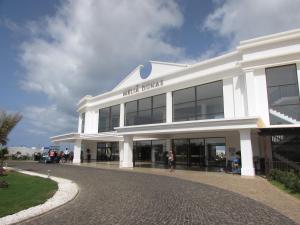 a white building with people standing outside of it at BCV Private 1 Bed Apartment Ground Floor Dunas Resort 6067 in Santa Maria