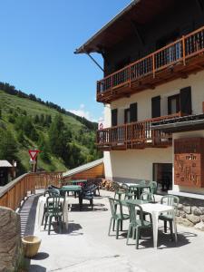 a group of tables and chairs in front of a building at Hôtel Le Monte Pente in Vars