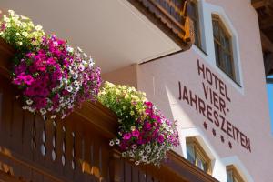 a building with flower baskets on the side of it at Hotel Vierjahreszeiten in Flachau