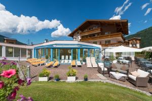 a house with a patio with chairs and tables at Hotel Vierjahreszeiten in Flachau