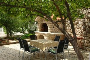 a table and chairs in front of a stone oven at Villa Nina in Novi Vinodolski