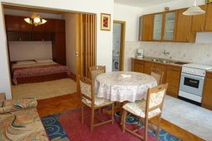 a kitchen with a table and a bedroom with a bed at Villa Nina in Novi Vinodolski