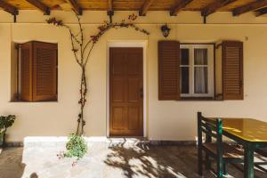 a house with a door and a table and a tree at Panorama Apartments updated with infinity pool in Agios Nikolaos