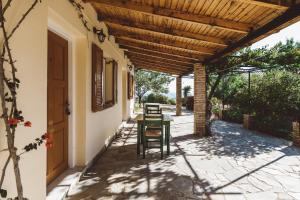 a patio with a table and chairs under a wooden pergola at Panorama Apartments updated with infinity pool in Agios Nikolaos