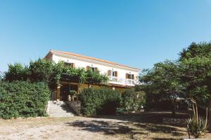 a large white house with trees in front of it at Panorama Apartments updated with infinity pool in Agios Nikolaos