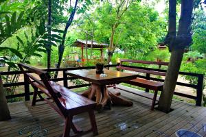Baan Chanoknunt Resort Pai في باي: طاولة وكراسي خشبية على سطح خشبي