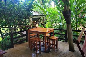 a wooden table and chairs on a wooden deck at Baan Chanoknunt Resort Pai in Pai