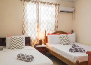 two beds in a room with a window at Darrel Cot Beachfront Cottage in Saint Peter