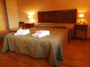pokój hotelowy z łóżkiem i ręcznikami w obiekcie Residence il Poggiolino w mieście Montecarelli +14 zdjęć