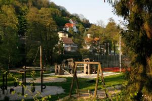 a playground in a park with trees and houses at Café und Pension Theodor Fontane in Altenbrak +2 photos