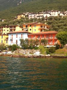 um grupo de casas numa colina junto à água em Hotel Smeraldo em Brenzone sul Garda