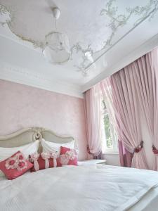 ein rosafarbenes Schlafzimmer mit einem Bett mit rosa Vorhängen in der Unterkunft Apart House Plesia in Marienbad