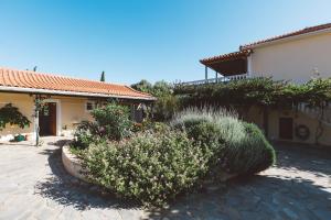 a house with bushes and flowers in front of it at Panorama Apartments updated with infinity pool in Agios Nikolaos