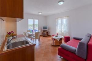 米歐納的住宿－Apartments Šimić，厨房以及带沙发和桌子的客厅。