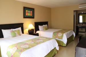 Coco Beach Hotel في كوكو: غرفة فندقية بسريرين ونافذة