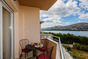 balcone con tavolo, sedie e vista sull'acqua di Apartments MARE a Trogir