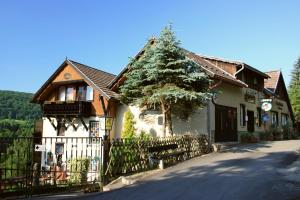 a building with a fence and a tree in front of it at Café und Pension Theodor Fontane in Altenbrak