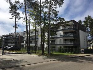 an apartment building with trees in front of it at Apartament Baltic Park - BEL MARE in Pogorzelica