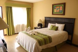 Coco Beach Hotel في كوكو: غرفة نوم بها سرير عليه حيوان محشو