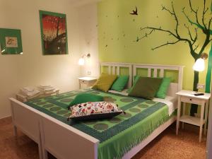 - une chambre avec un lit et un arbre sur le mur dans l'établissement B&B Caronte Messina, à Messina