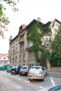un groupe de voitures garées devant un bâtiment dans l'établissement Great Central Apartment, à Sibiu