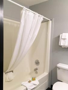 baño con ducha con cortina blanca en The Bulldog Hotel en Silver Star