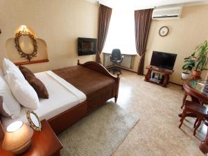 a hotel room with a bed and a television at Studio De Luxe with Jacuzzi in Sumy