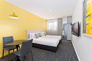 a hotel room with a bed and a table at Value Suites Green Square in Sydney