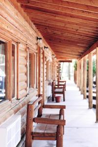 una fila de bancos sentados en el porche de un edificio en The Longhorn Ranch Resort Lodge & RV Park en Dubois