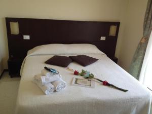 a bed with two towels and two pillows on it at Hotel Okinawa in Rimini