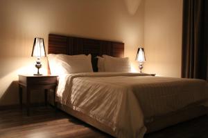 a bedroom with a large white bed with two lamps at شقق درر رامه للشقق المخدومة 3 in Riyadh