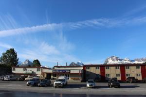 um parque de estacionamento com carros estacionados em frente a um hotel em Glacier Hotel em Valdez