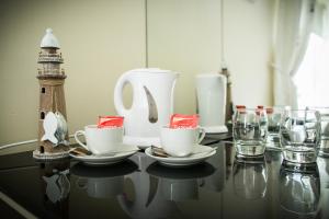 a table with cups and glasses and a lighthouse at Pairc Lodge in Doolin