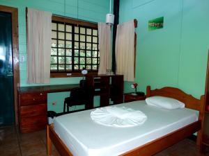 um quarto com uma cama, uma secretária e uma janela em La Selva Biological Station em Sarapiquí