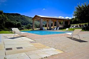 two chairs and a gazebo next to a pool at Amico Country House in Serra San Quirico