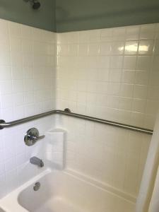 a bathroom with a bath tub with a sink at Economy Inn in Modesto +16 photos