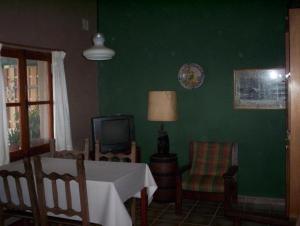 comedor con mesa y pared verde en Verde Niña Casas Serranas en Cortaderas