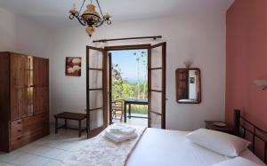 a bedroom with a bed and a door to a balcony at Monemvasia Village (ex Topalti) in Monemvasia