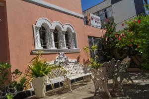 a bench in front of a building with flowers and plants at Pousada O Ninho in Salvador