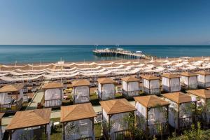 a row of houses on a beach next to the ocean at Delphin Imperial Lara in Lara