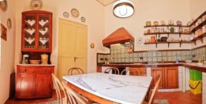 a kitchen with a table and chairs in a room at Casa Barone Agnello in Cefalù