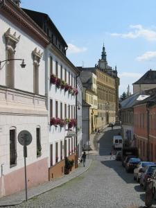 a street in a town with buildings and cars at Hotel U Dómu sv. Václava in Olomouc