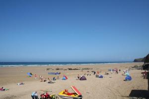 a group of people on a beach near the ocean at Beachcombers Apartments in Newquay